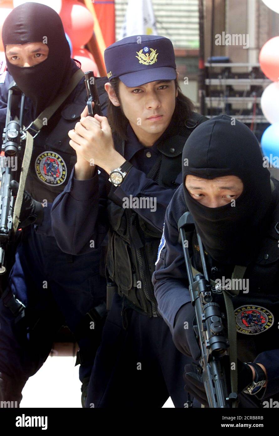 Taiwan Singer And Actor Jimmy Lin C Poses With Members Of A Swat Team For Photographers During A News Conference In Taipei July 16 2002 Lin Has Recently Become A Spokesman To