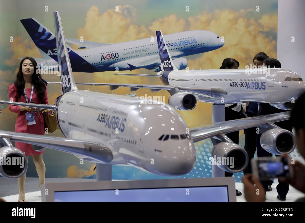 A visitor stands next to models of Airbus A380 and A330 at the Aviation Expo China 2015, in Beijing, China, September 16, 2015. The four-day Aviation Expo China 2015 kicked off on Wednesday. According to local media, the expo is jointly organized by Aviation Industry Corporation of China (AVIC), Commercial Aircraft Corporation of China Ltd. (COMAC) and etc. Around 150 exhibitors from 16 countries were invited. REUTERS/Jason Lee Stock Photo