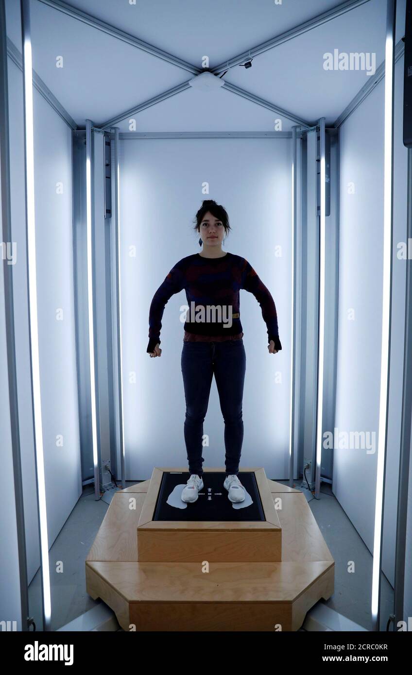 A staff member uses a laser body scanner to measure a customer's size  before the individual knitting of a sweater at the Adidas Knit for You  store in Berlin, Germany March 7,