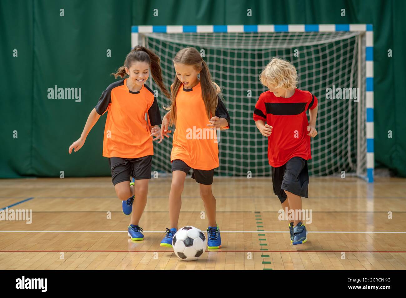 Kids in sportswear running after the ball Stock Photo
