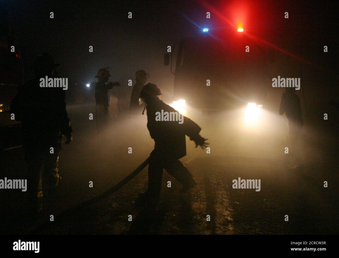 Sri Lankan fire fighters attempt to extinguish a fire at Bata shoe factory early on Friday, south of Colombo August 13, 2004. The company had been shut down during last the few weeks due to problems between the workers' union and management. REUTERS/Anuruddha Lokuhapuarachchi  AL/SH Stock Photo