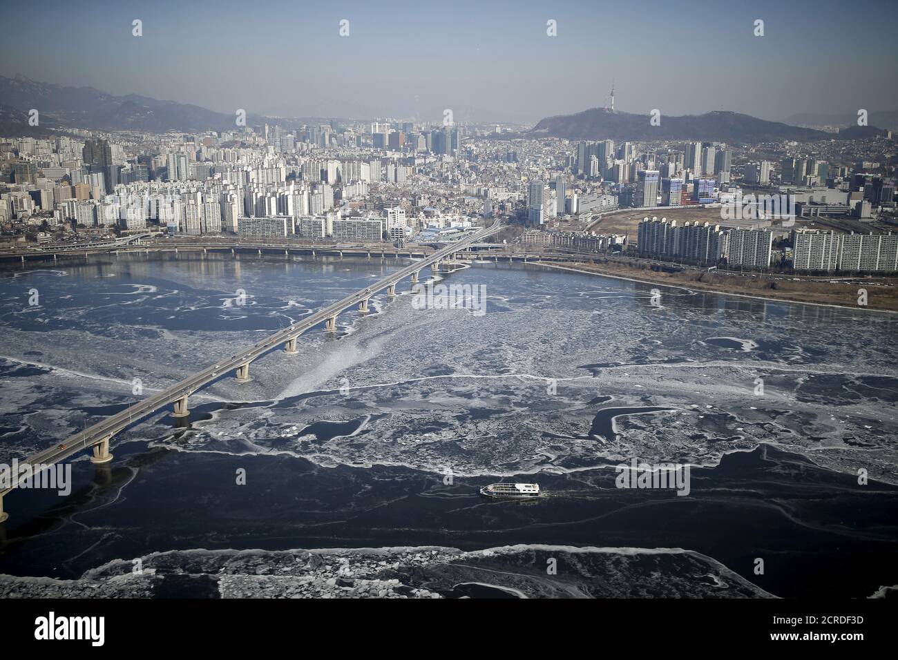 A passenger ship (bottom) navigates through the ice flow in the Han River in Seoul, South Korea, January 25, 2016. A cold snap hit South Korea on Sunday with the temperature in Seoul falling to minus 18 degree Celsius. REUTERS/Kim Hong-Ji      TPX IMAGES OF THE DAY Stock Photo
