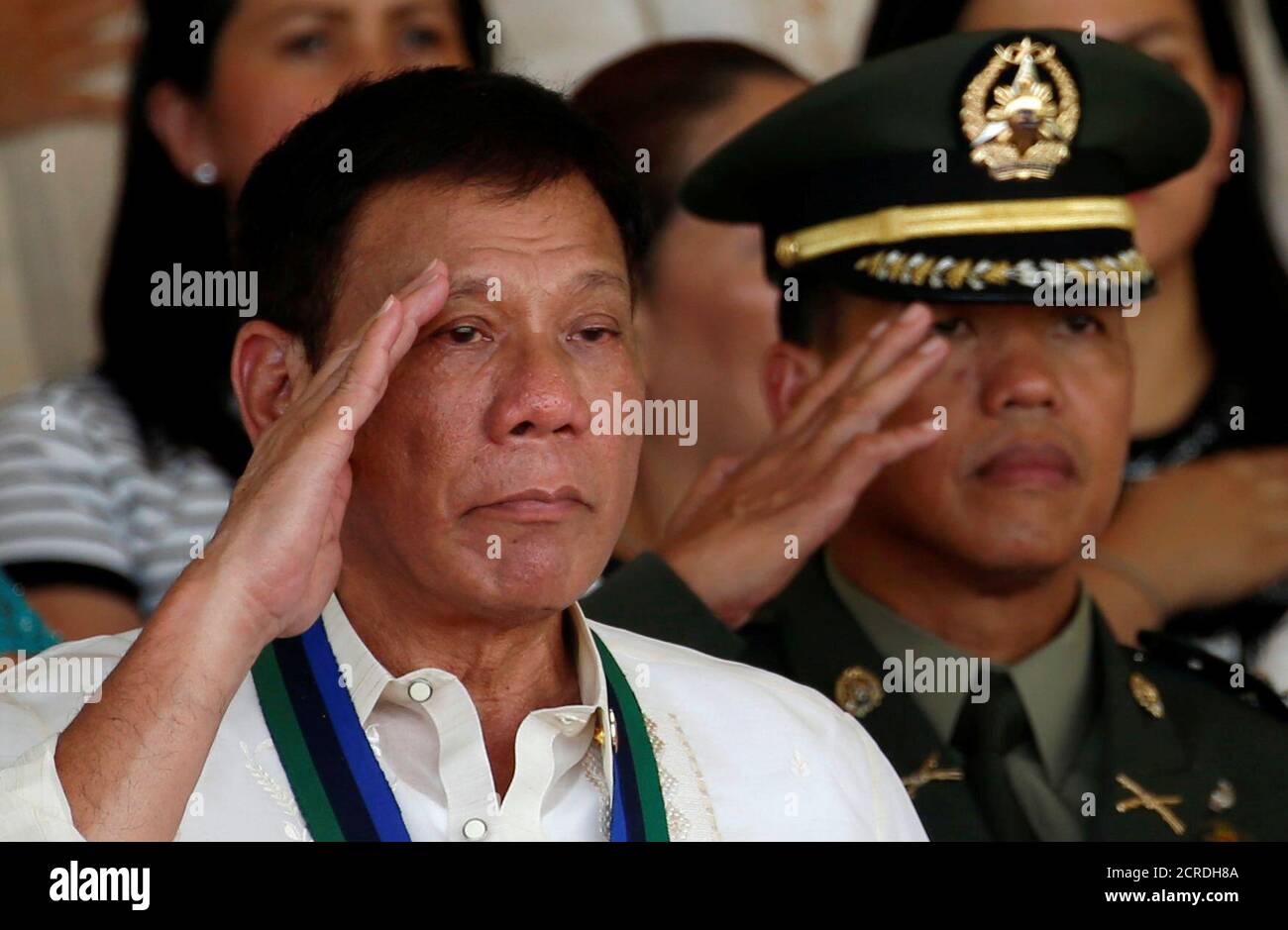 Philippines President Rodrigo Duterte salutes next to a military