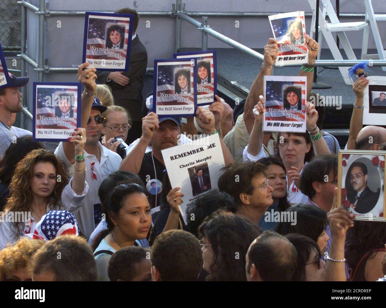 Family members hold pictures of their lost loved ones as they wait to attend an anniversary ceremony in New York, September 11, 2002. First anniversary ceremonies to mark the attack on the World Trade Center are being held across the nation. REUTERS/Jim Bourg  PJ/ME Stock Photo