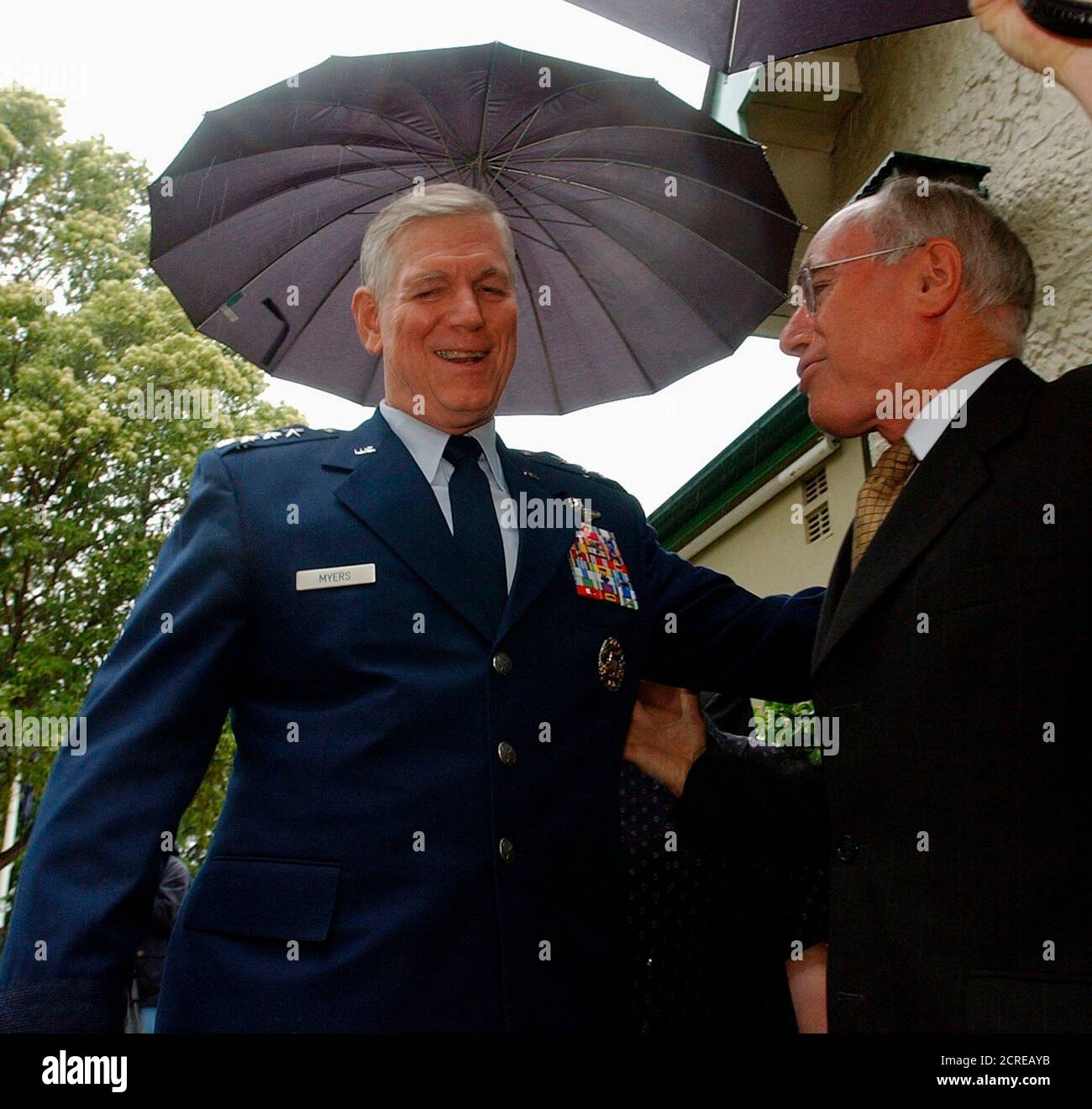 Chairman of the United States Joint Chiefs of Staff, General Richard Myers (L), is met by Australian Prime Minister John Howard at Howard's Sydney residence as rain falls January 16, 2004. General Myers is visiting Australia as part of a nine-day international tour. REUTERS/Rick Rycroft/Pool  RR/MY Stock Photo
