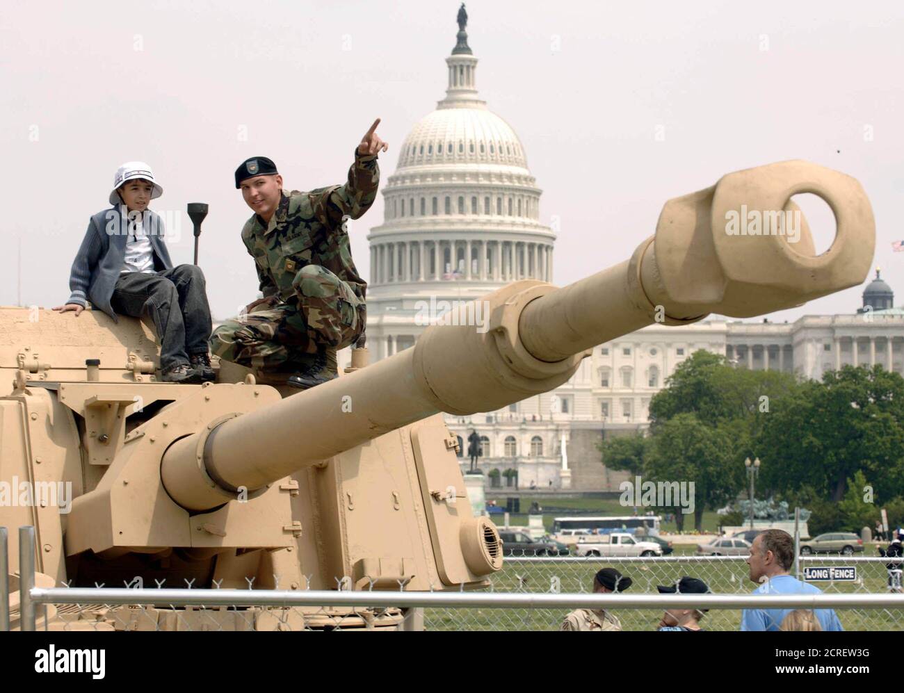U.S. Army Sgt. Shaun Saki points out the barrel of his tank to nine-year-old Mark Bernshtam (L) on the Mall near the U.S. Capitol in Washington, May 5, 2005. The Army is hosting Public Service Recognition Week, with displays of military hardware from all the branches of the U.S. military. Saki is the tank gunner from A 2/5 Field Artillery, 221th Bde, Fort Sill, Oklahoma. REUTERS/Mannie Garcia  mg Stock Photo