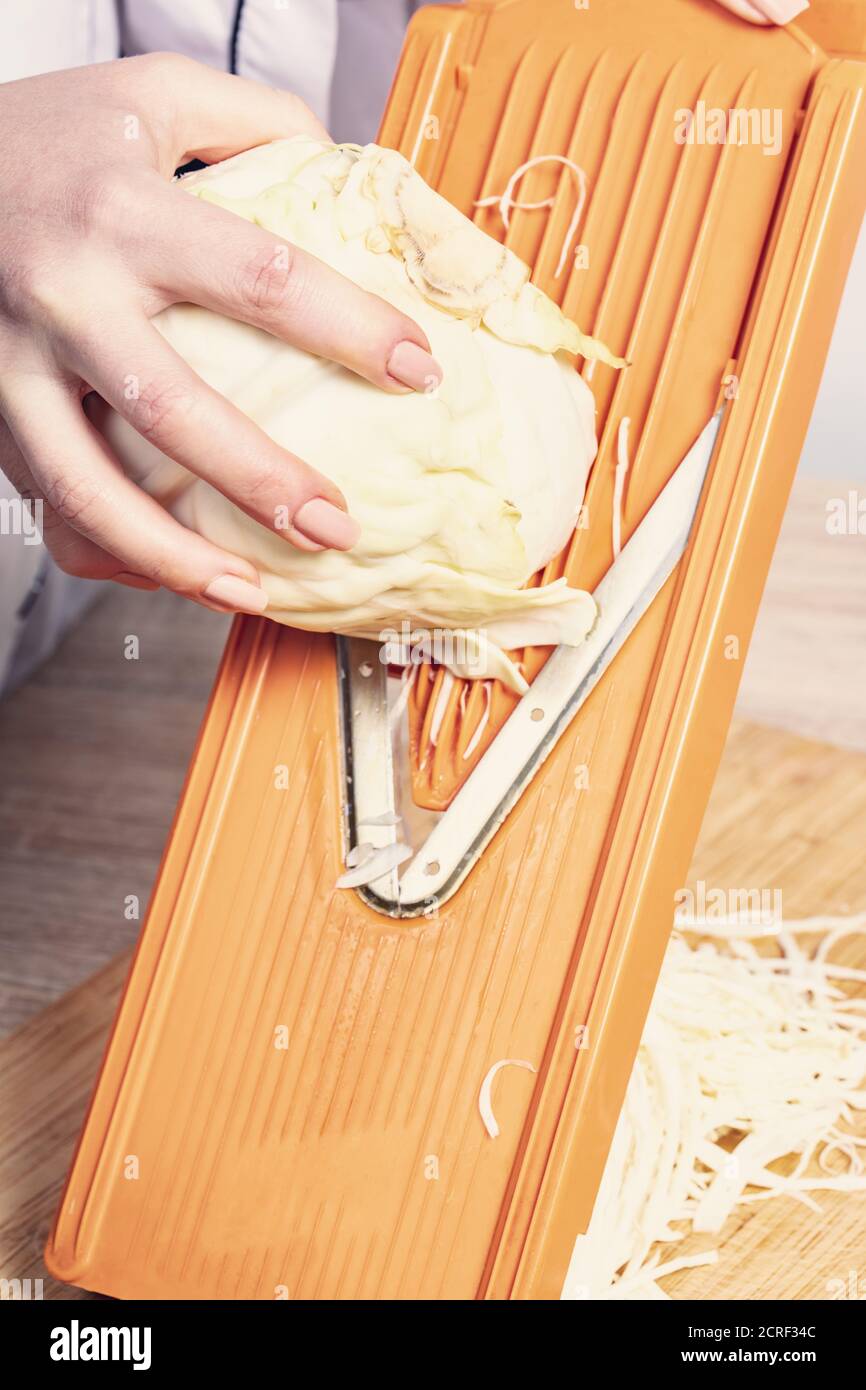 Wooden cabbage grater, piece of cabbage, carrot, assorted pepper and  himalayan salt on cutting board and on blue wooden table. Flat lay with  cabbage f Stock Photo - Alamy