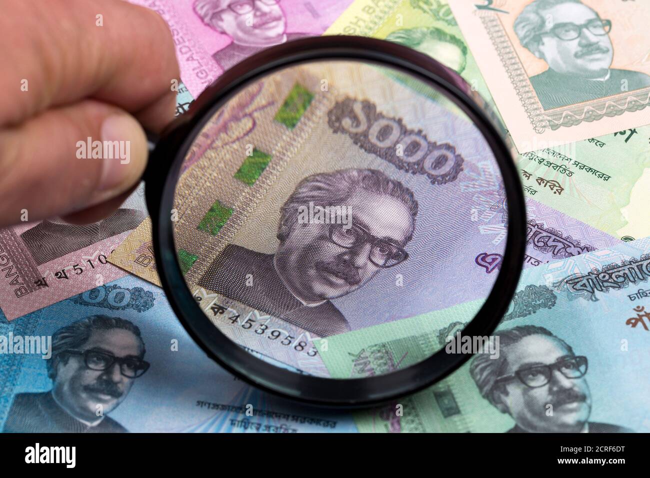 Currency of Bangladesh in a magnifying glass a business background Stock Photo Alamy