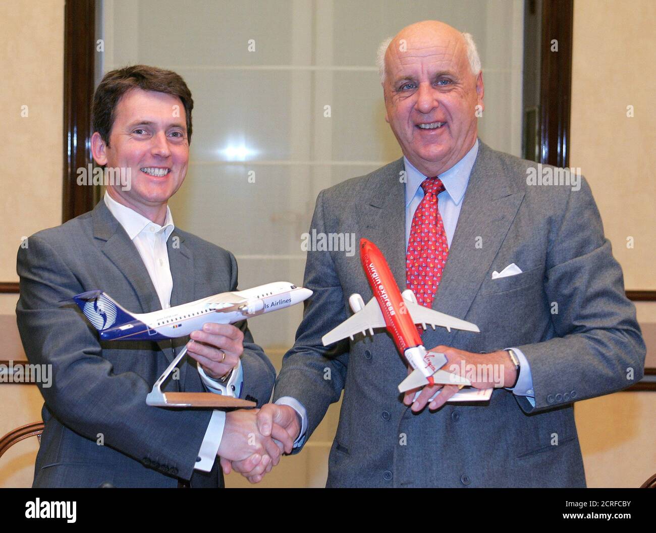 Virgin Management's Chief Executive Officer Stephen Murphy (L) shakes hands with SN Airholding Chairman Etienne Davignon (R) at the start of a news conference in Brussels October 6, 2004. Full-fare operator SN Brussels Airlines said on Wednesday it had finalised its planned tie-up with low-cost carrier Virgin Express, in a deal that ends rivalry between the two companies based at Brussels's main airport. REUTERS/Thierry Roge  THR/acm Stock Photo