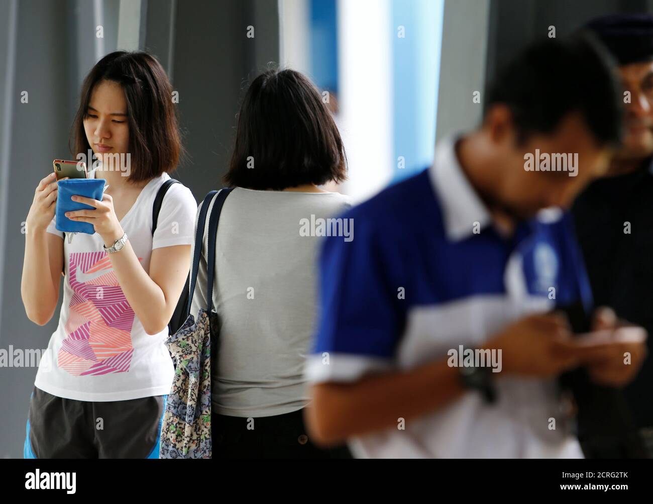 A student uses her mobile phone at an university in Semenyih, outside Kuala Lumpur, Malaysia November 3, 2017. REUTERS/Lai Seng Sin Stock Photo