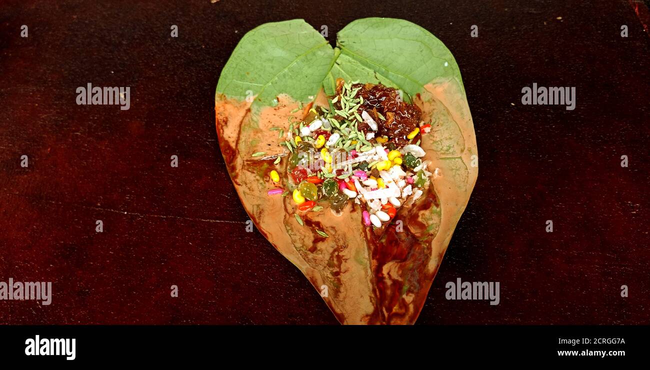 Isolated Pan made with sweet fruit flavor spice, indian betel leaf