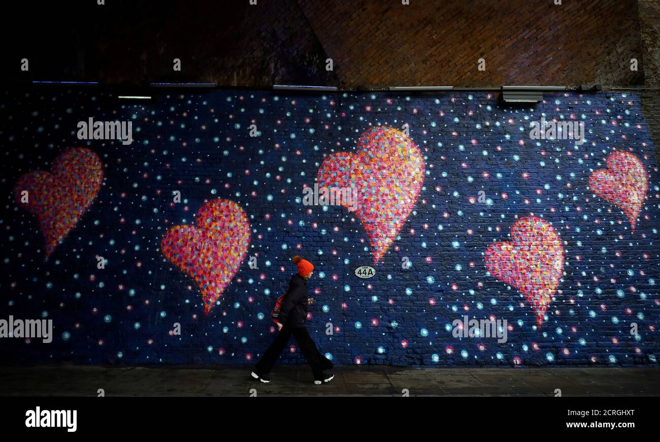 A woman walks past a mural, by British-born Australian artist James Cochran, painted to commemorate the victims of the London Bridge attack, in London, Britain, April 2, 2018. REUTERS/Hannah McKay     TPX IMAGES OF THE DAY Stock Photo