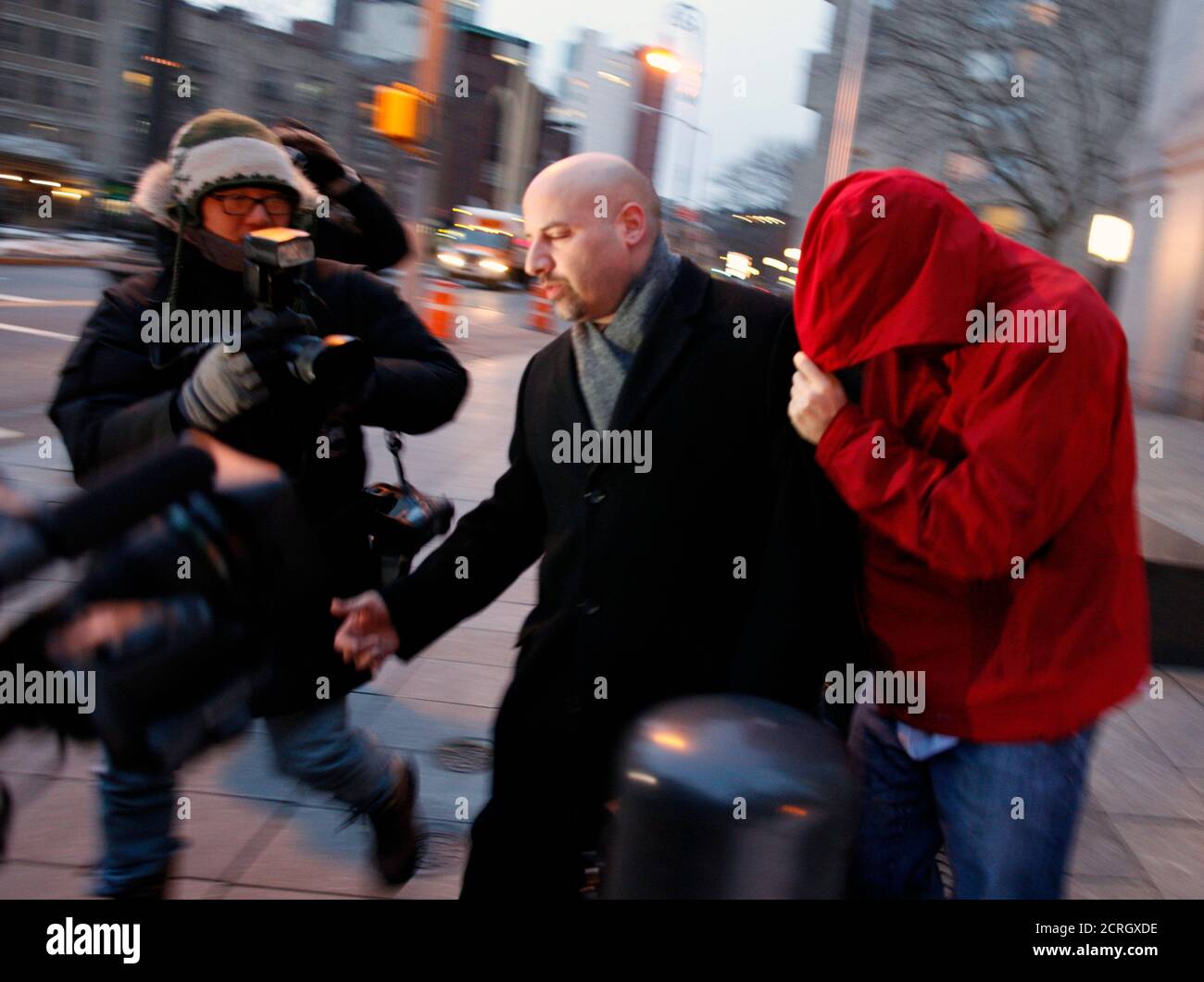 Former SAC Capital Advisers employee Donald Longueuil covers his face as he is led by his lawyer from the Manhattan Federal Courthouse in New York February 8, 2011. Two people, including Longueuil, who once worked for billionaire trader Steven A. Cohen's SAC Capital Advisers were charged with insider trading, drawing the $12 billion hedge fund firm further into a high-profile investigation.    REUTERS/Brendan McDermid (UNITED STATES - Tags: CRIME LAW BUSINESS) Stock Photo