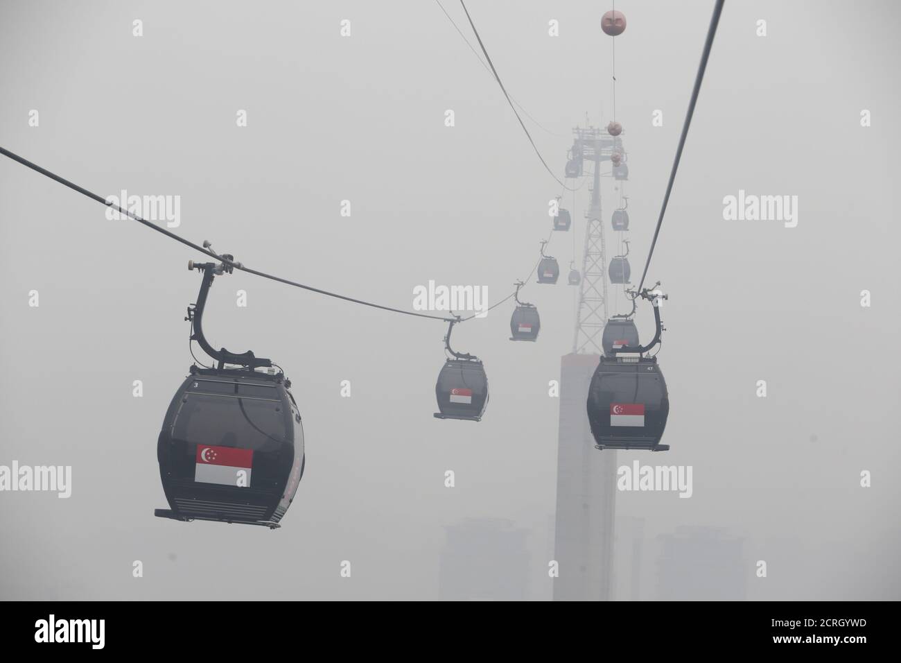 Cable cars moving towards the island resort of Sentosa are shrouded by haze in Singapore September 29, 2015. The 3-hour haze Pollutant Standards Index (PSI) was at 205 at 11am on Tuesday, according to the National Environment Agency. Slash-and-burn agriculture in neighbouring Indonesia has blanketed Singapore in a choking haze for weeks.   REUTERS/Edgar Su       TPX IMAGES OF THE DAY Stock Photo