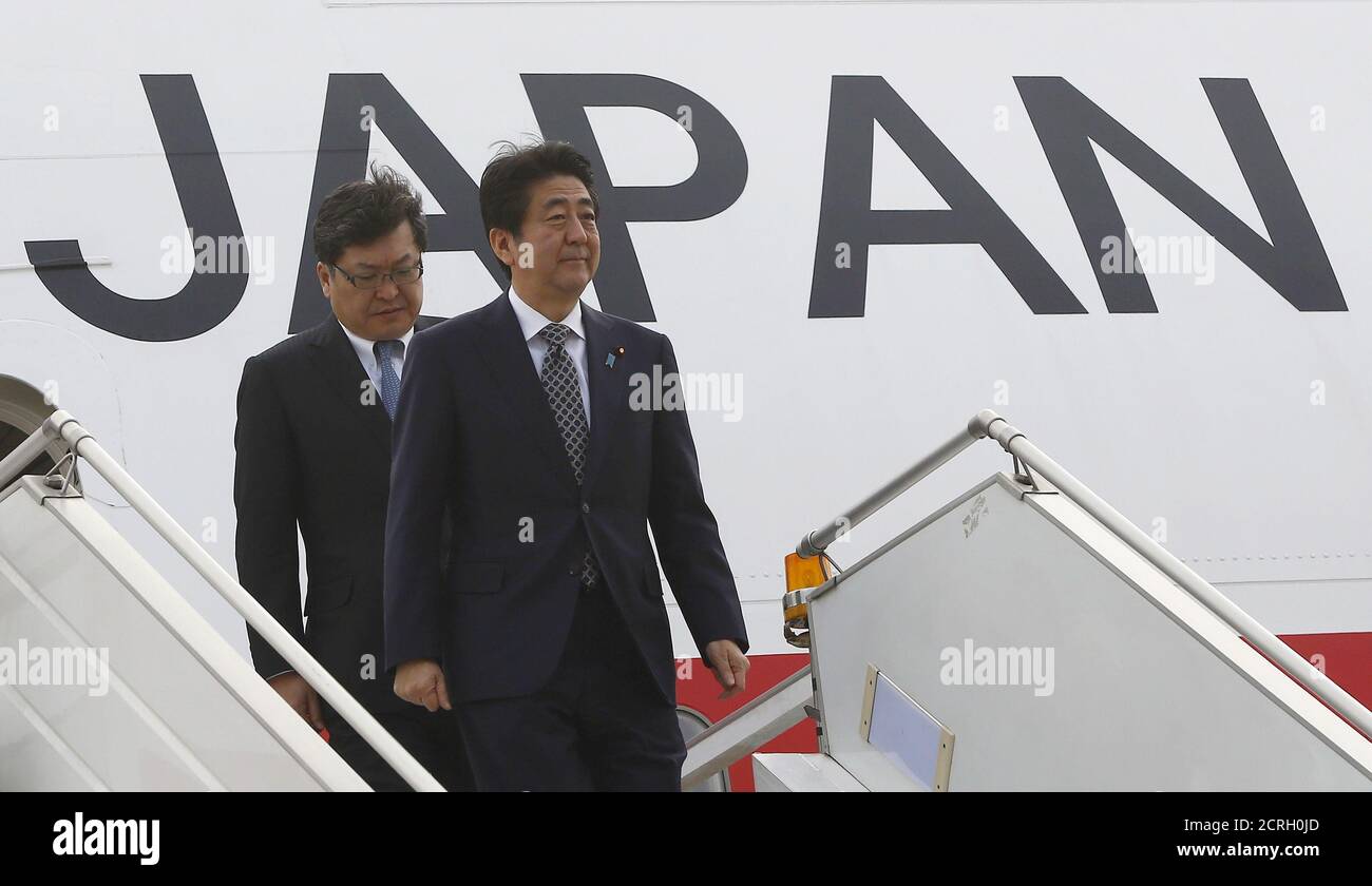 Japan's Prime Minister Shinzo Abe (R) disembarks from an aircraft upon his arrival at the airport in New Delhi December 11, 2015. India and Japan are likely to finalize an agreement on protection of military information during Abe's trip beginning on Friday that will the lay the ground for Japanese arms sales to India, including seaplanes. REUTERS/Adnan Abidi Stock Photo
