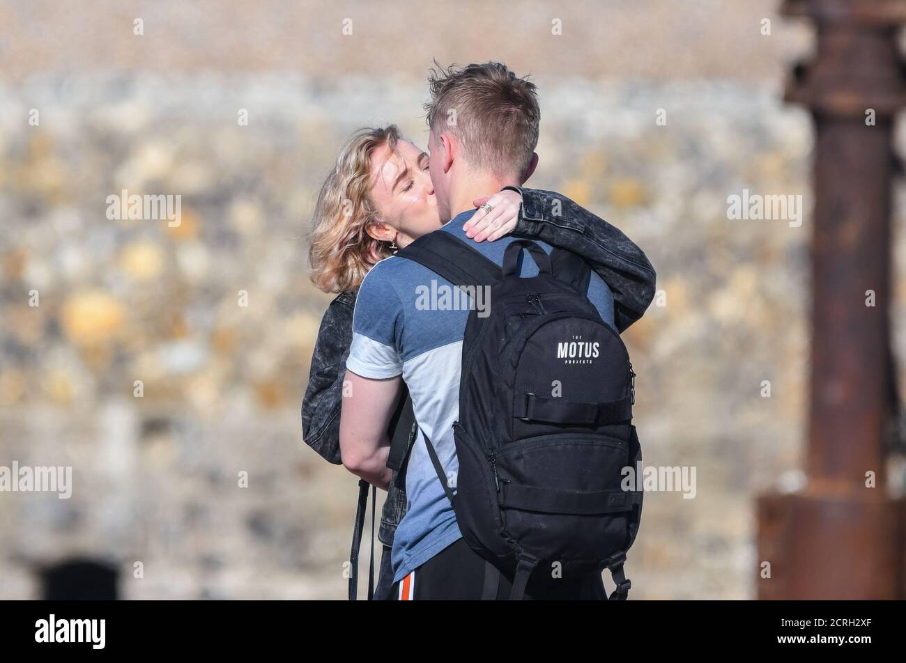 Young couple showing public display of affection as they kiss on a beach. Young love concept. PDA. Stock Photo