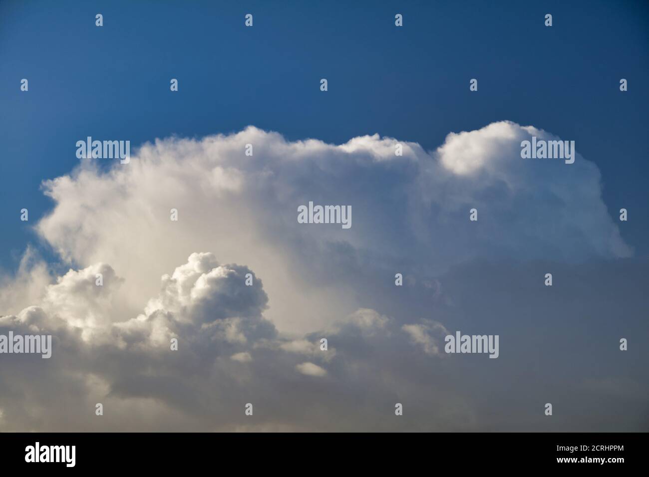 Fluffy cumulus cloud against a deep blue sky Stock Photo - Alamy