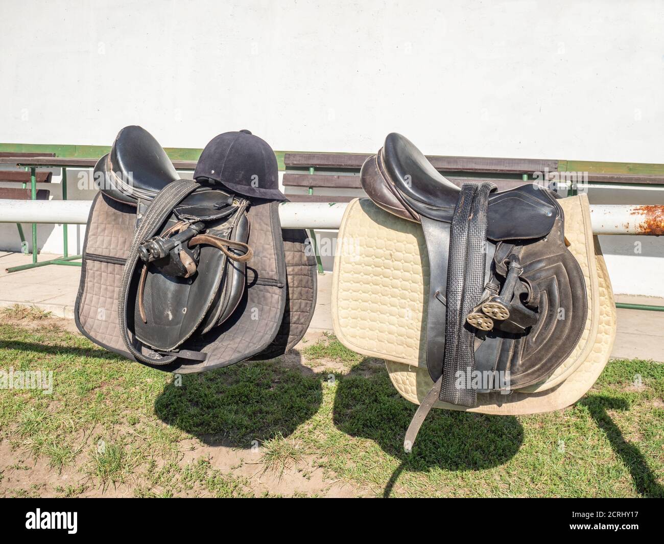 Leather saddle on mooring beam with stirrups. Children ridding school on a horse farm Stock Photo