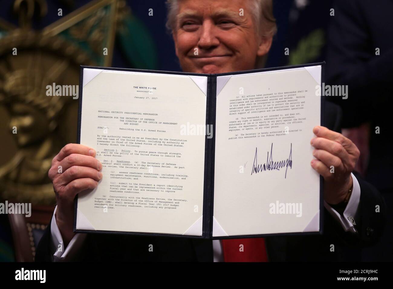 U.S. President Donald Trump shows an  executive action he said would begin the rebuilding of the U.S. military by 'developing a plan for new planes, new ships, new resources and new tools for our men and women in uniform' after signing it, at the Pentagon in Washington, U.S., January 27, 2017. REUTERS/Carlos Barria Stock Photo