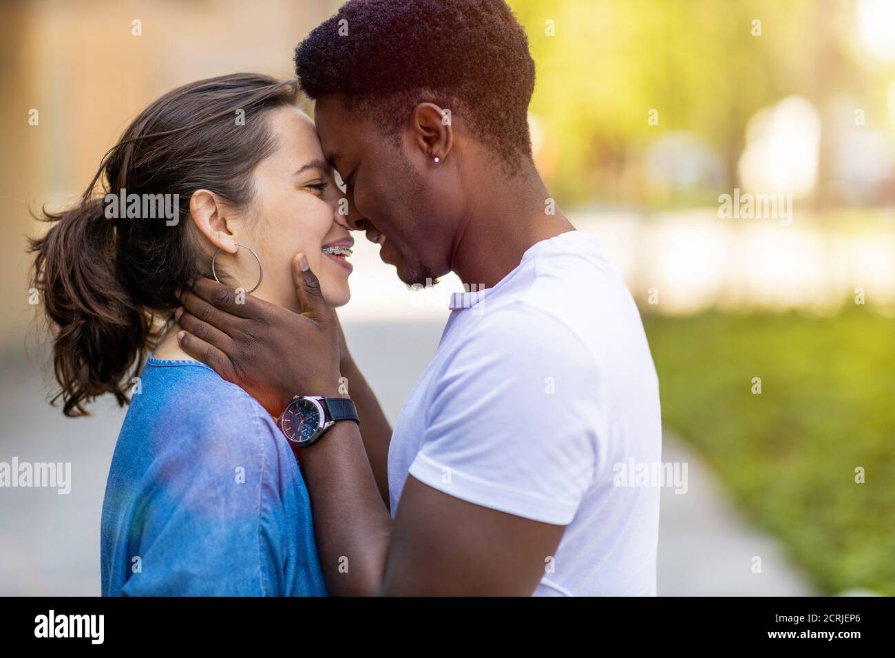 Multiracial young couple kissing outdoors Stock Photo