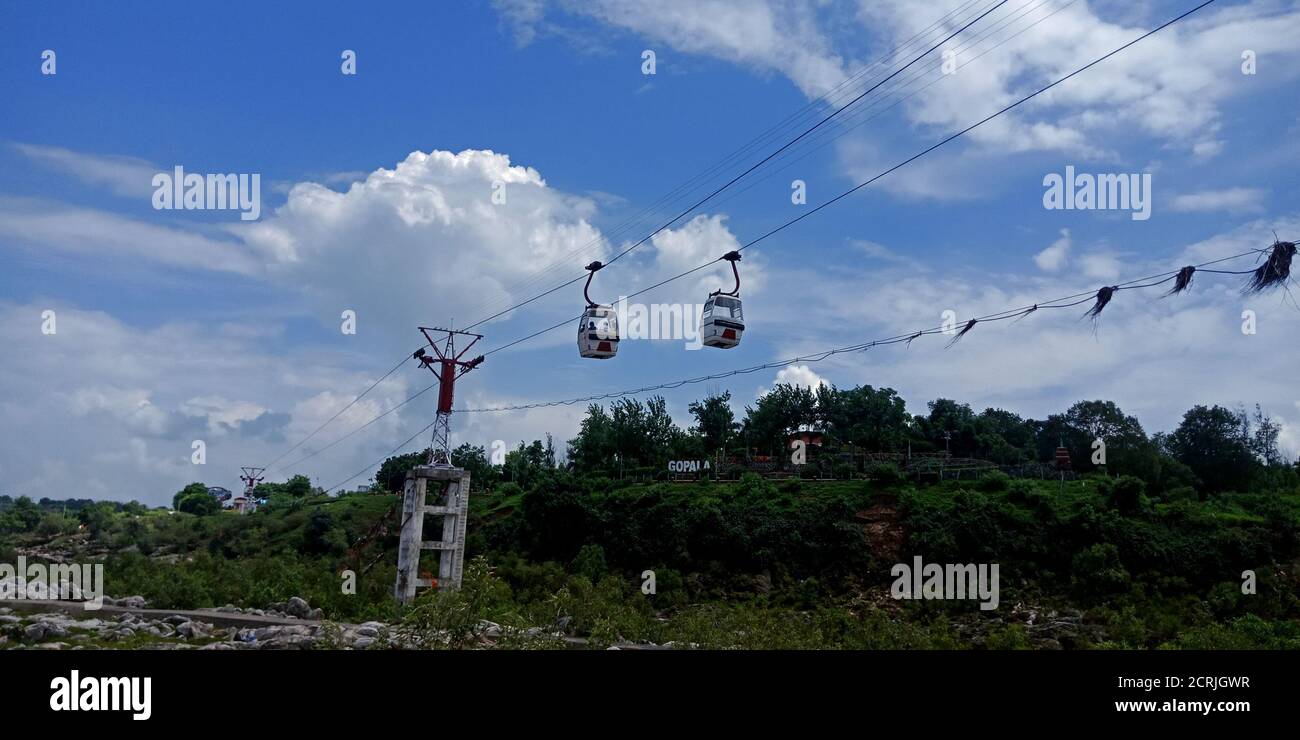 Ropeway Trolly car hanging on river side hill station in beautiful blue ...