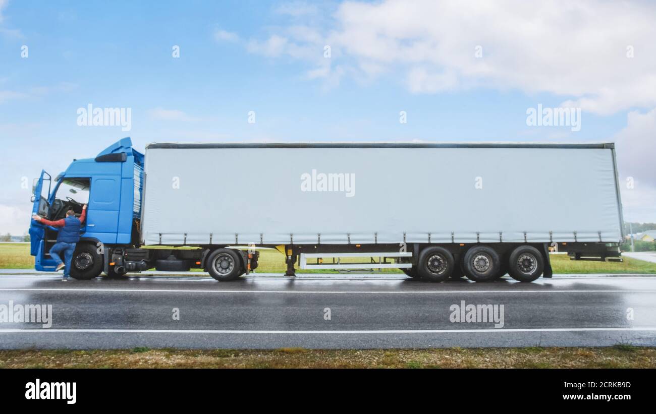 Truck Driver Crosses the Road in the Rural Area and Gets into His Blue