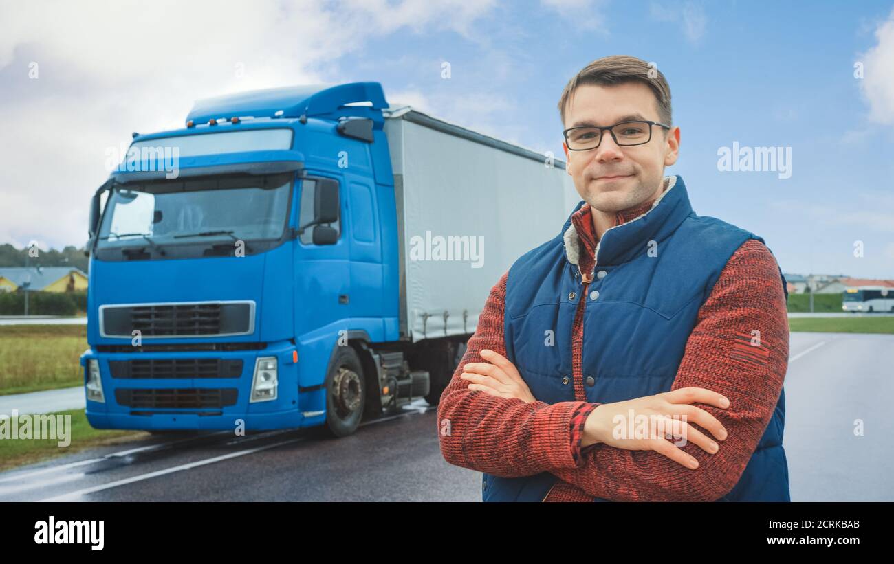 Happy Professional Young Truck Driver Crosses Arms and Smiles on Camera