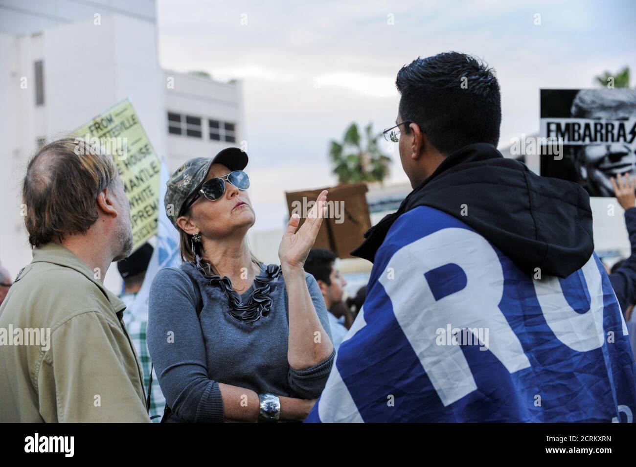 Melanie Chapman (C) talks with Danny Rodriguez (R), a Trump supporter, at an anti-Trump protest in a park a few miles from a gated community where U.S. President Donald Trump is holding a fundraiser in Beverly Hills, California, U.S. March 13, 2018. REUTERS/Andrew Cullen Stock Photo