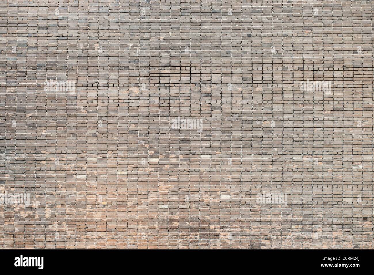 Weathered stained old brick wall background on surface Stock Photo