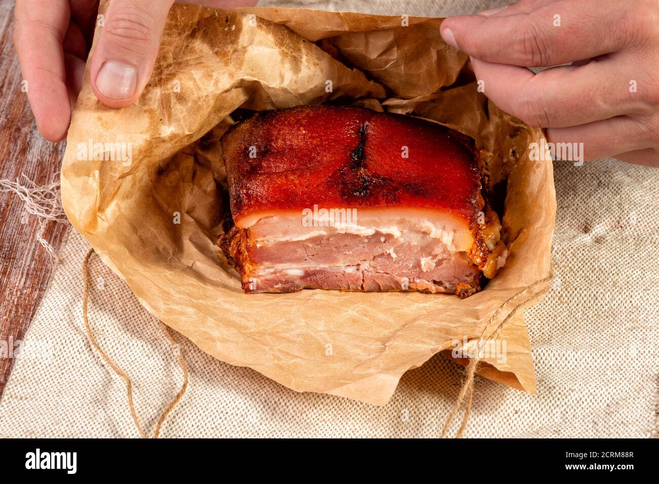 smoked meat wrapped in wrapping paper and tied with twine Stock Photo
