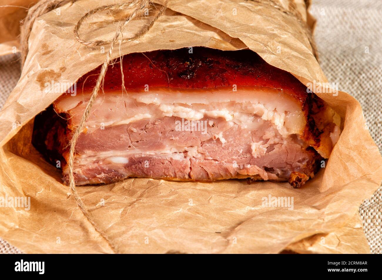 smoked meat wrapped in wrapping paper and tied with twine Stock Photo