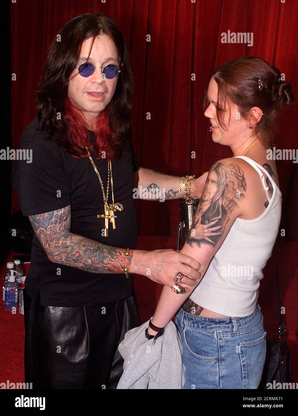 Rock musician Ozzy Osbourne greets fan Kelly Bulaich of San Pedro,  California as he admires her tattoos during Osbourne\