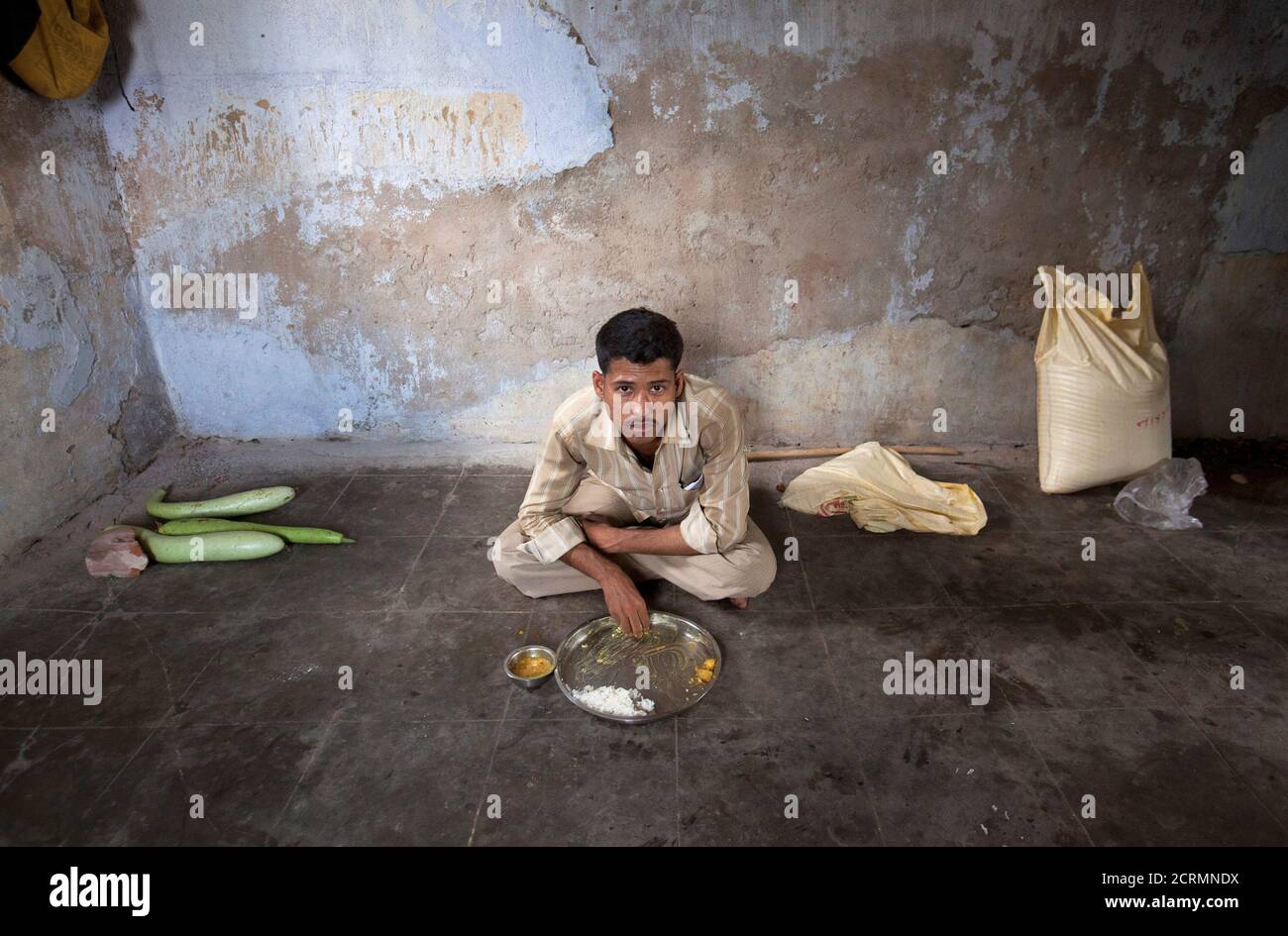 An unmarried man eats his lunch in the remote village of Siyani, where they also live and work in, about 140km (86 miles) west of Gujarat's capital Ahmedabad, October 5, 2011. Siyani is typical of many Indian villages and may be an indicator of things to come as India's male to female ratio declines. The village has some 350 unmarried men over the age of 35 - and hundreds more under 35 - because there aren't enough women to marry. Many women have also left to look elsewhere for grooms with more money and better prospects. Census data released earlier this year revealed there are 914 girls for  Stock Photo