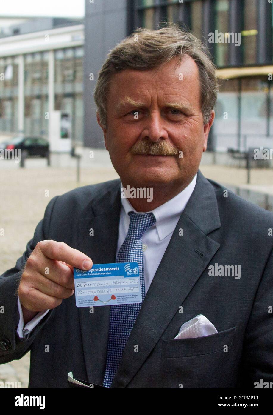 The head of the German Medical Association Frank Ulrich Montgomery (Bundesaerztekammer) shows his organ donation card to reporters before a crisis session to review the distribution praxis of donated organs in Berlin, August 9, 2012. The meeting was held on Thursday following a scandal in at least two hospitals where patients received preferred treatment against an additional fee.    REUTERS/Thomas Peter (GERMANY - Tags: HEALTH) Stock Photo