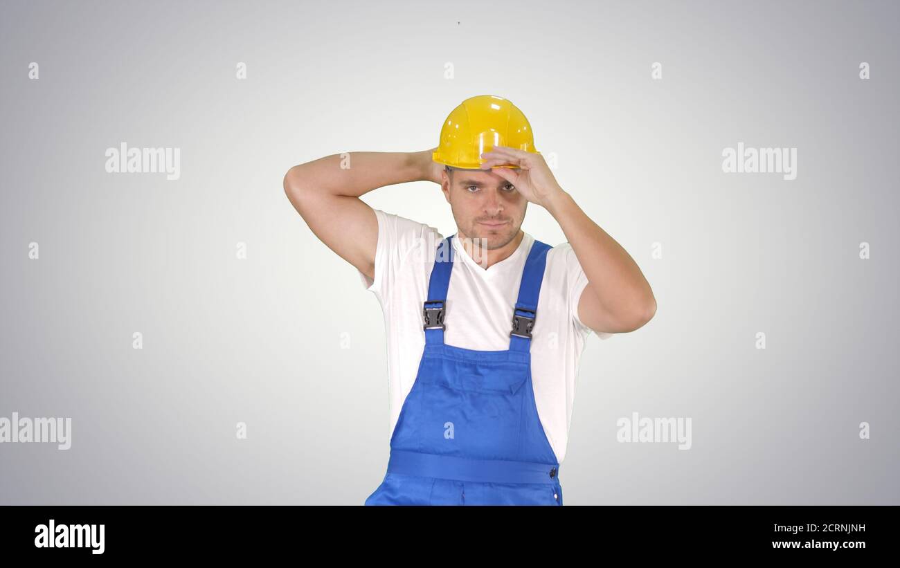 Construction worker walking and putting on hard hat or helmet on Stock Photo
