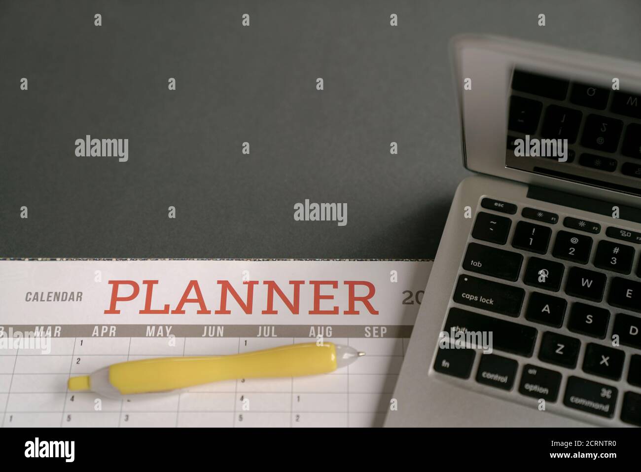 Calendar planner with computer laptop on table. Planning and organizing activities concept. Stock Photo