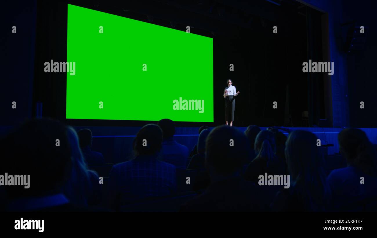 Keynote Speaker Announces New Product to the Audience, Behind Her Movie Theater with Green Screen, Mock-up, Chroma Key. Female CEO Shows Leadership on Stock Photo