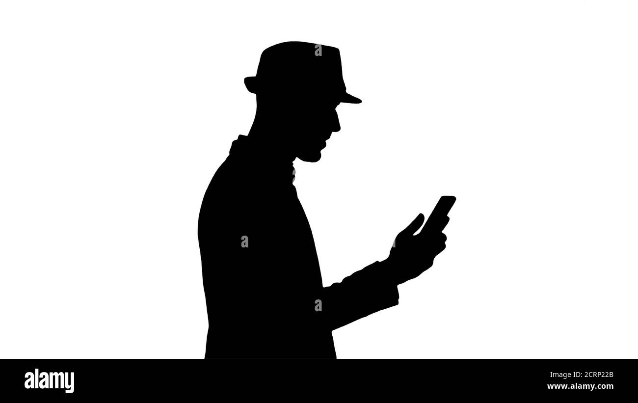 Silhouette Man walking with a phone and serfing internet. Stock Photo