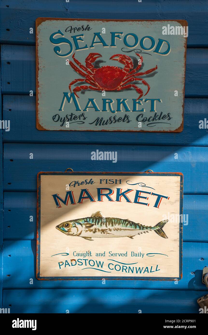 Seafood, posters bill boards, crab, oysters, mussels, cockles, mackerel, fresh fish, fish market, Padstow Cornwall, caught served daily, blue boards. Stock Photo