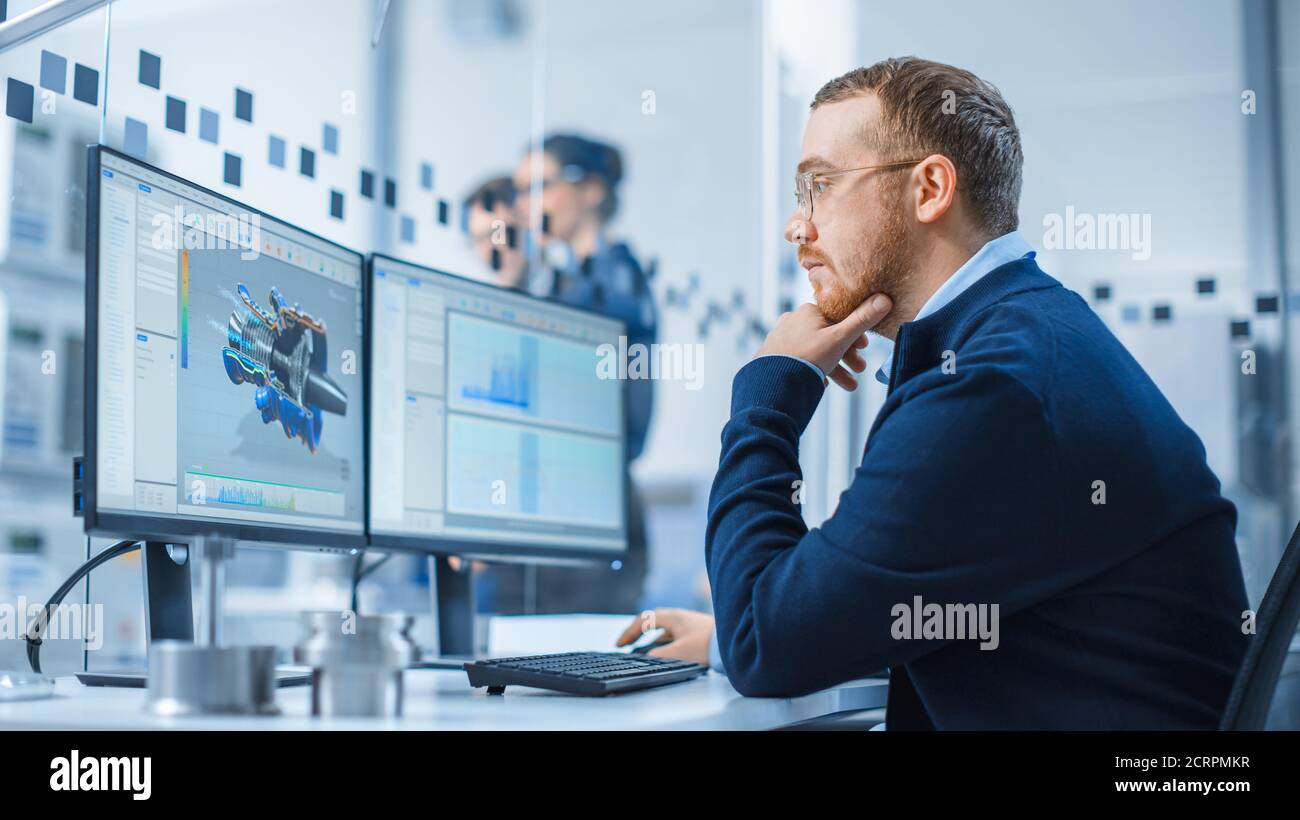 Industrial Engineer Working on a Personal Computer, Two Monitor Screens