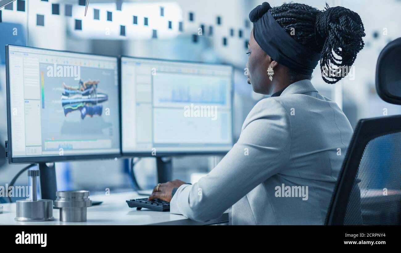 Beautiful Female Engineer Working on Personal Computer in the High-Tech ...