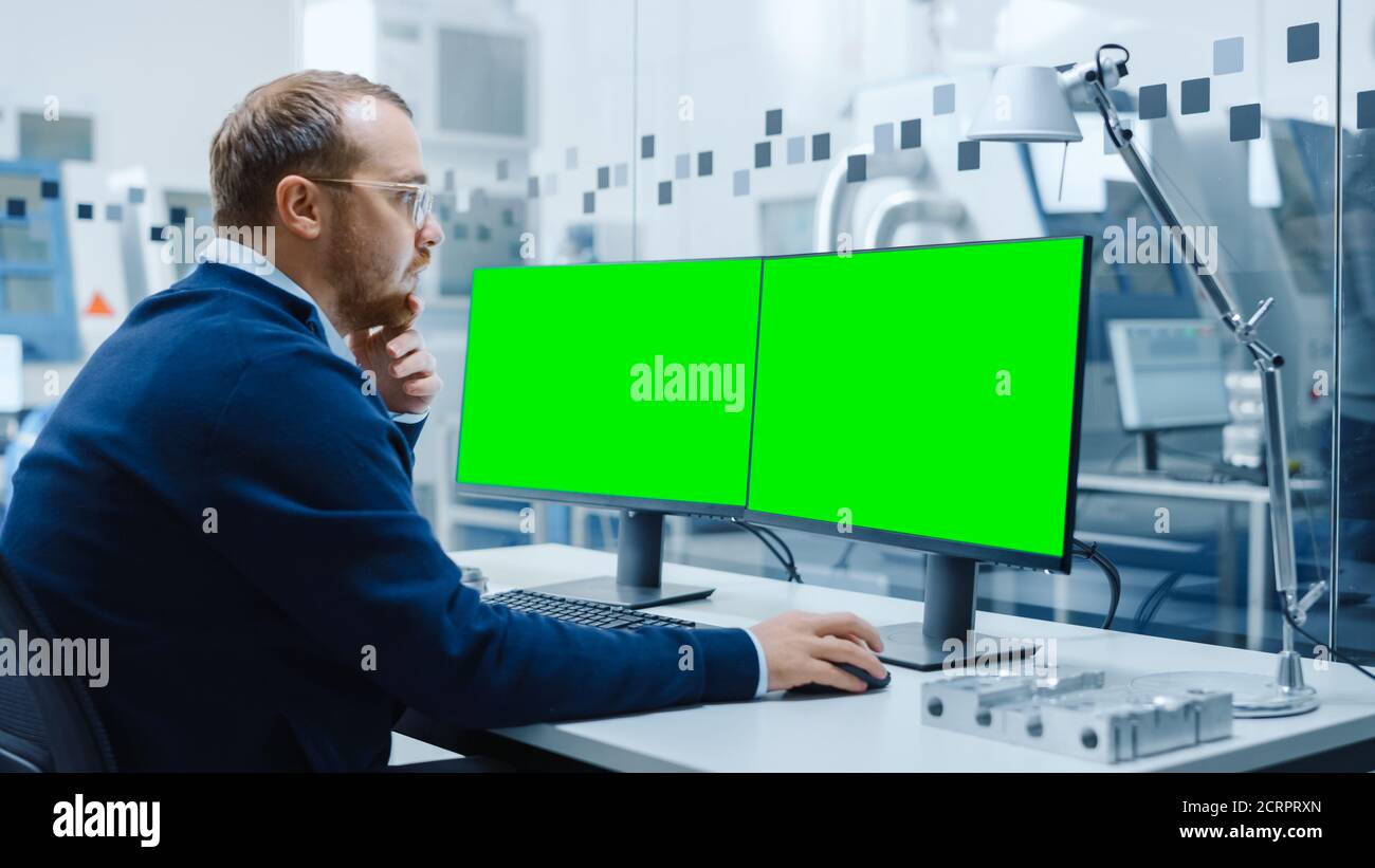Industrial Engineer Working on a Personal Computer, Two Monitor Screens