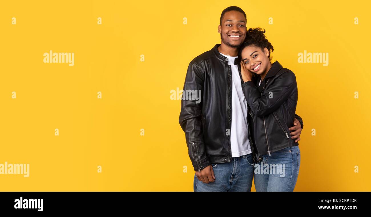 African Couple Hugging Posing Wearing Black Leather Jackets, Studio Shot Stock Photo