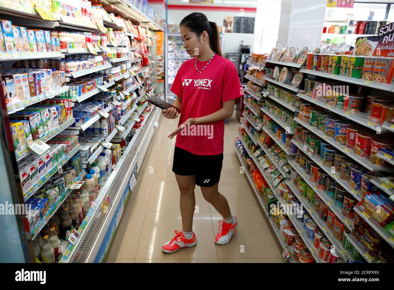Thailand's badminton player Ratchanok Intanon (C), who hopes to win gold at  the Rio Olympics, shops after an afternoon training session at a  convenience store in Bangkok, Thailand, June 22, 2016. Picture