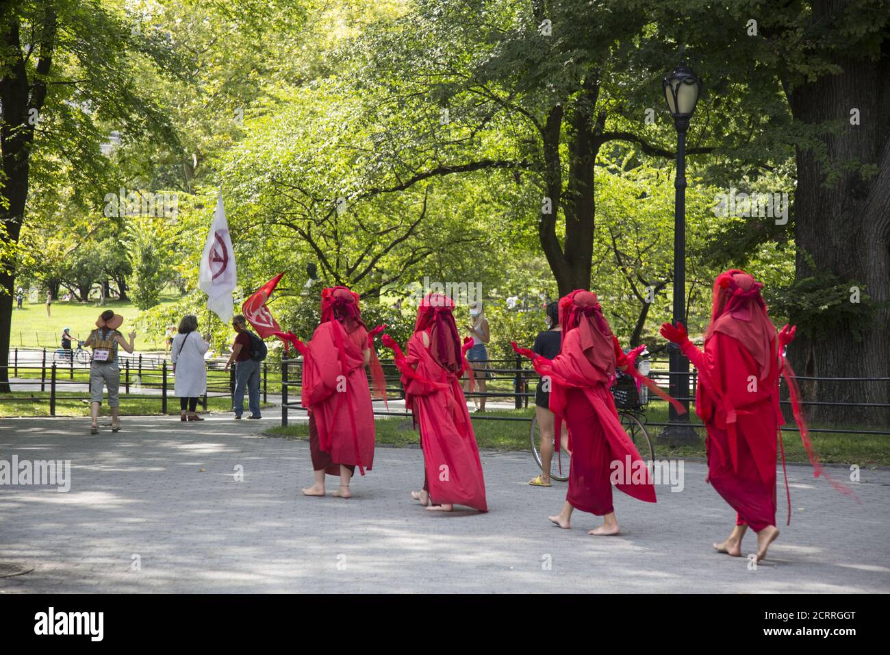 The Red Rebels, Brigade, who are a branch of Extinction Rebellion, dressed in bright red to signify the blood of species that have died as a result of climate change, as well as those that will die in the future demonstrate and march at Bethesda Fountain in Central Park organized by 'Extinction Rebellion' to bring attention to the immediate need for system change in the US and around the world to combat  the climate crisis that is now being experienced world wide in the form of wildfires, hurricanes, droughts and floods along with air and water pollution at an unprecedented scale. Stock Photo
