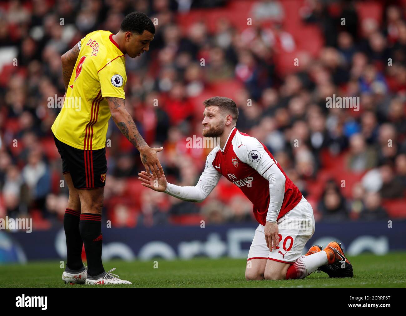 Soccer Football - Premier League - Arsenal vs Watford - Emirates Stadium, London, Britain - March 11, 2018   Watford's Troy Deeney helps up Arsenal's Shkodran Mustafi    REUTERS/Eddie Keogh    EDITORIAL USE ONLY. No use with unauthorized audio, video, data, fixture lists, club/league logos or 'live' services. Online in-match use limited to 75 images, no video emulation. No use in betting, games or single club/league/player publications.  Please contact your account representative for further details. Stock Photo