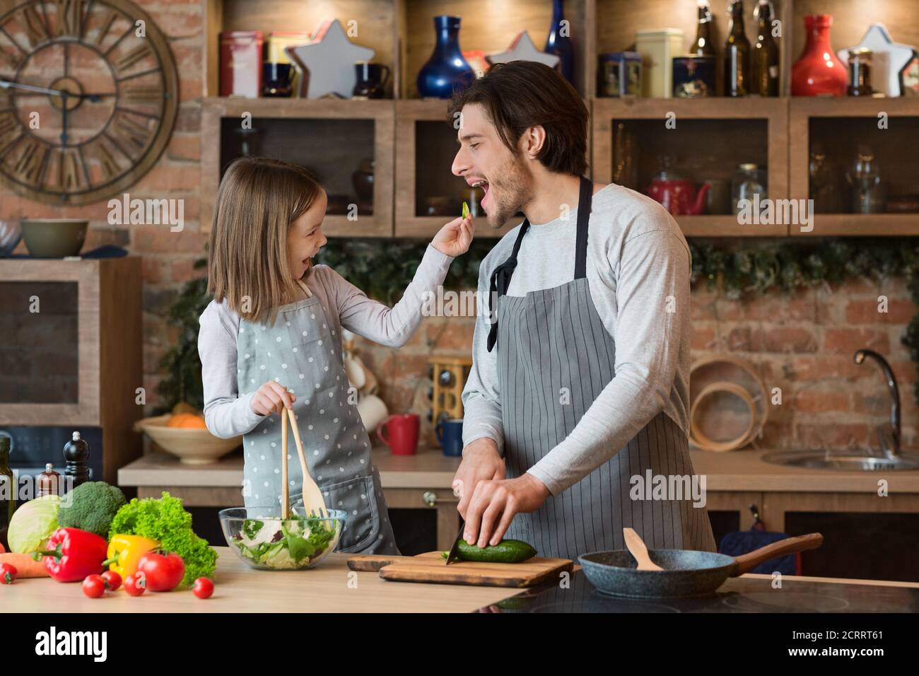 Happy Young Family Father And Daughter Having Fun While Cooking In Kitchen Stock Photo