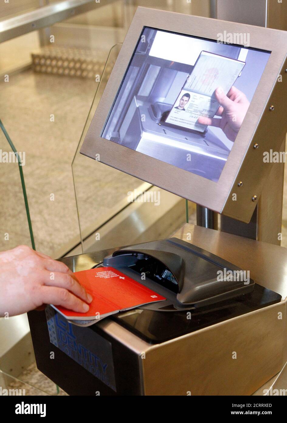 A man puts his biometric passport on a scanner at an automatic border  control point during a media presentation at Zurich-Kloten airport December  1, 2010. The machine, designed to replace passport control