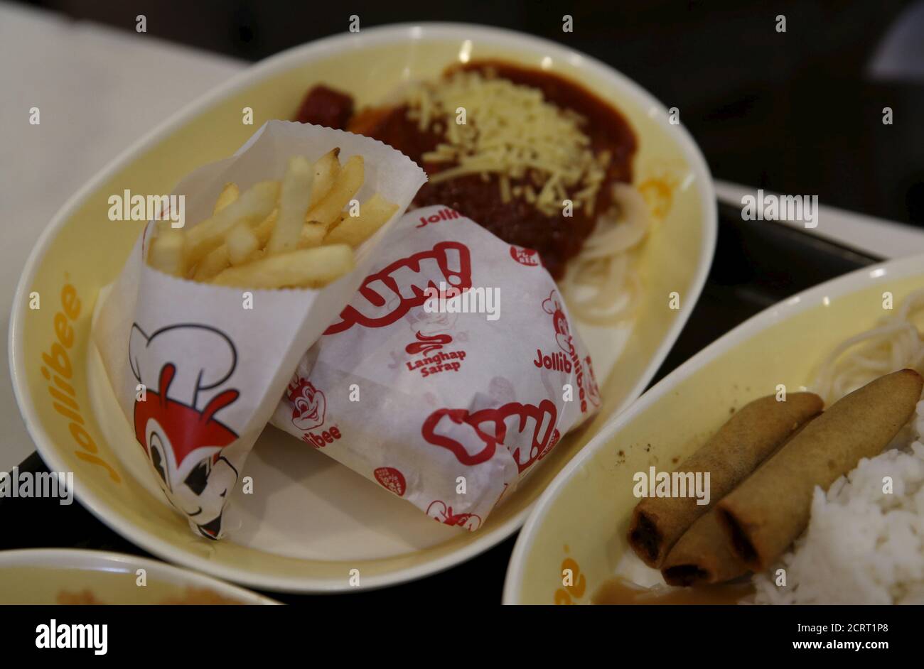 A plate combination of French Fries, Burger Yum and Jolly spaghetti, and a plate of Lumpia Shanghai with rice are pictured  inside a Jollibee franchise in BF Homes Paranaque, Metro Manila, March 3, 2016.   REUTERS/Erik De Castro Stock Photo