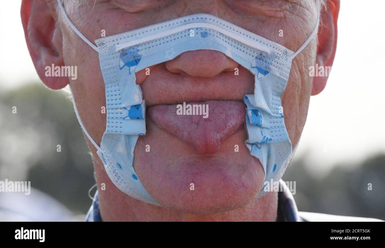 Duesseldorf, Germany. 20th Sep, 2020. A participant in a demonstration protests on the Rhine meadows with a cut-up mask and tongue stuck out against the measures to combat the coronavirus. Credit: Roberto Pfeil/dpa/Alamy Live News Stock Photo